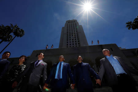 Members of the Los Angeles City Council and guests, including council president Herb Wesson (C), stand for a moment of unity during the "Hands Around City Hall" event in recognition of the 25th anniversary of the start of the LA riots, in Los Angeles, California April 28, 2017. REUTERS/Patrick T. Fallon