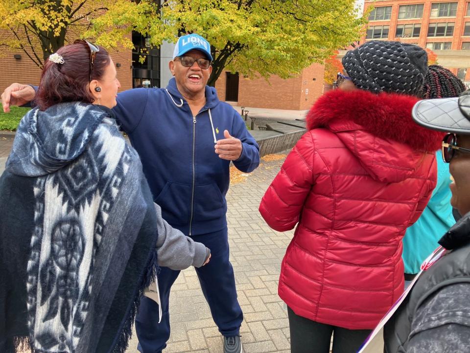 Pastor and attorney Daniel Reid collects hugs after handing out $20 bills to strikers last week on the UAW’s Blue Cross Blue Shield of Michigan picket line along Lafayette Boulevard.