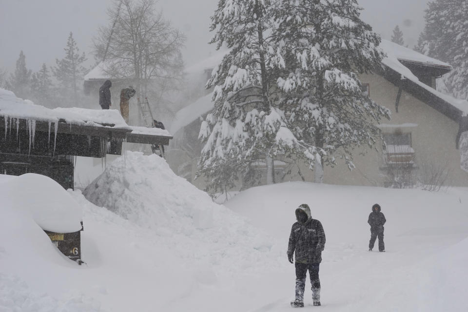 Workers clear snow off a roof during a blizzard Sunday, March 3, 2024, in Olympic Valley, Calif. (AP Photo/Brooke Hess-Homeier)