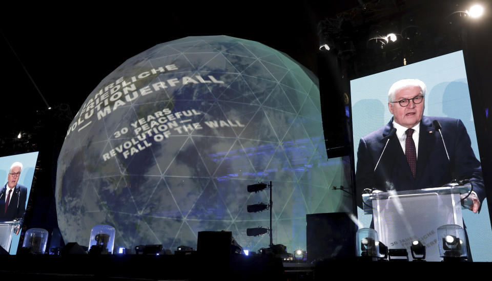 German President Frank-Walter Steinmeier is seen on giant video screens as he delivers a speech in front of the Brandenburg Gate as part of stage presentations to celebrate the 30th anniversary of the fall of the Berlin Wall in Berlin, Germany, Saturday, Nov. 9, 2019. (AP Photo/Michael Sohn)