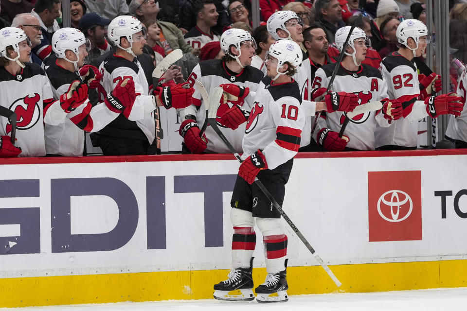 New Jersey Devils right wing Alexander Holtz (10) is congratulated for his goal against the Washington Capitals during the first period of an NHL hockey game Tuesday, Feb. 20, 2024, in Washington. (AP Photo/Alex Brandon)