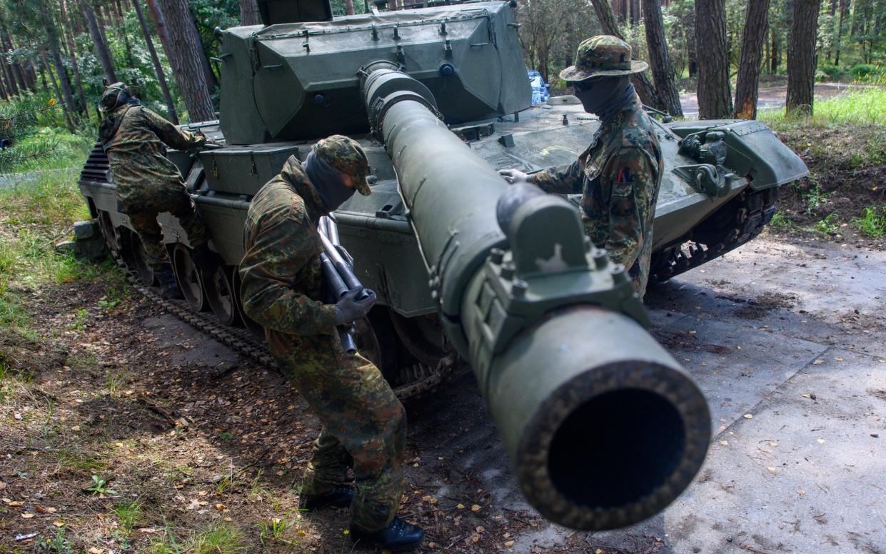 Ukrainian soldiers prepare to clean the gun barrel of a Leopard 1 A5 main battle tank