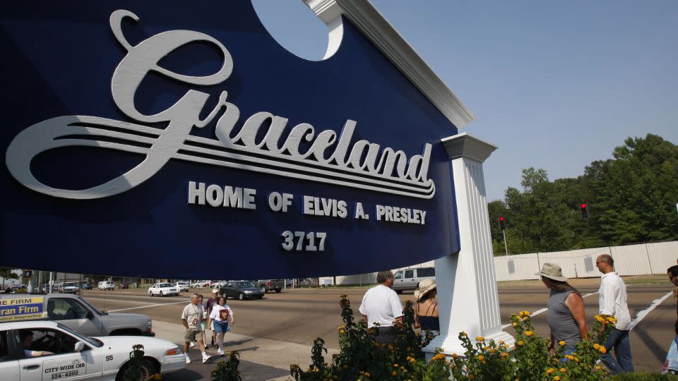 Fans walk by the entrance to Graceland, the home of Elvis Presley, on August 14, 2007, in Memphis, Tennessee. - Stan Honda/AFP/Getty Images