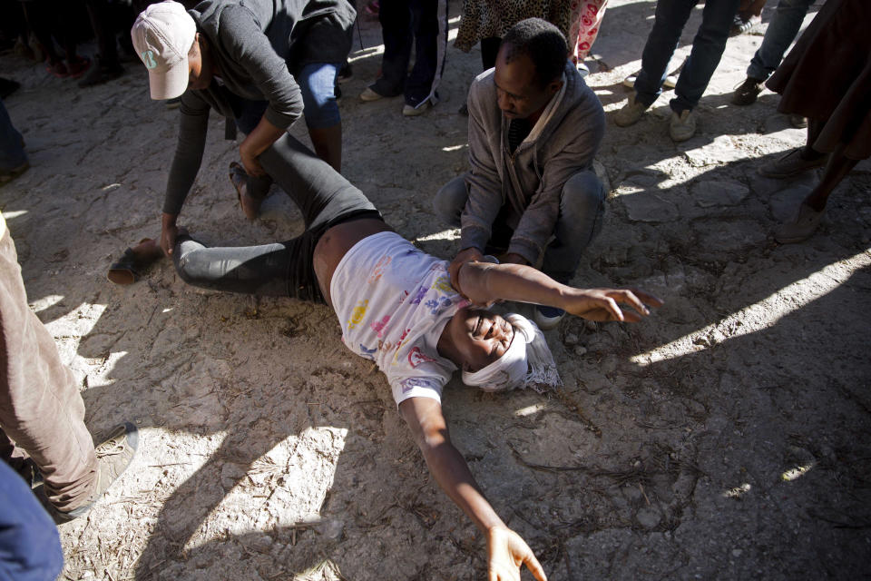 A pregnant woman cries after discovering her twin children died in a fire at the Orphanage of the Church of Bible Understanding outside the children's home the morning after the fire broke out in Kenscoff, on the outskirts of Port-au-Prince, Haiti, Friday, Feb. 14, 2020. A fire swept through this orphanage run by a Pennsylvania-based nonprofit group, killing over a dozen children, according to health care workers. (AP Photo/Dieu Nalio Chery)