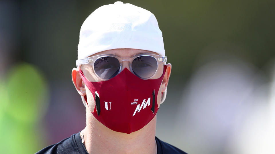 Seen here, Russian Formula 2 driver Nikita Mazepin looks on while wearing a face mask.