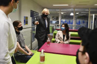 Britain's Prime Minister Boris Johnson, background centre left, meets Sixth form students during a visit to Accrington Academy in Accrington, England, Thursday, Feb. 25, 2021 as they prepare for the return of all pupils on March 8, (Anthony Devlin/Pool Photo via AP)