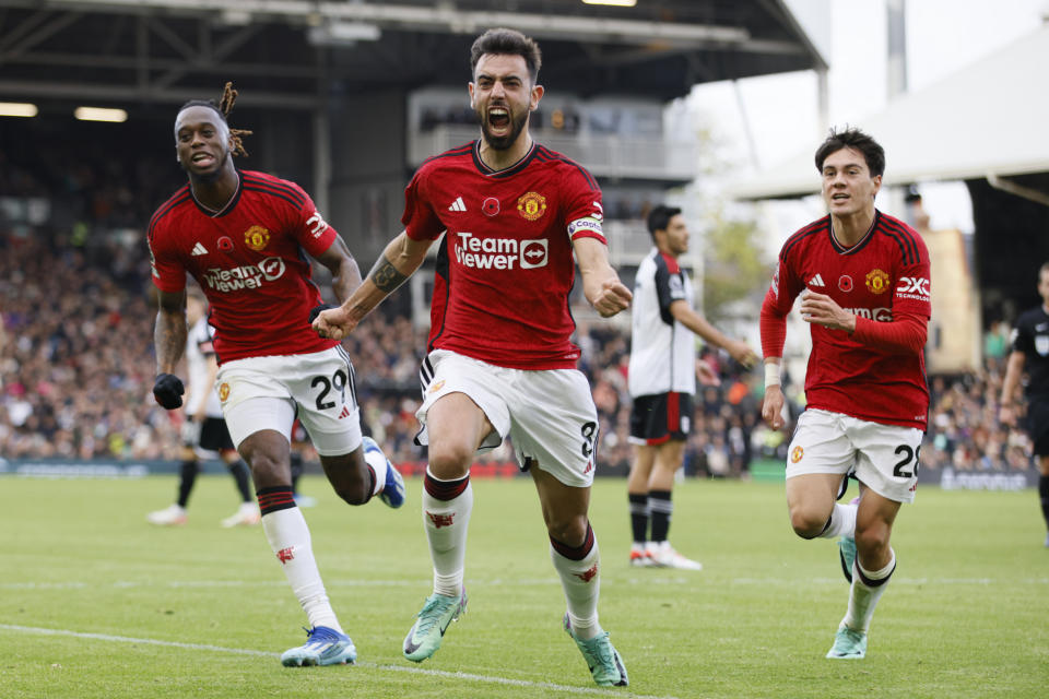 Manchester United's Bruno Fernandes, centre, celebrates after scoring his side's opening goal during the English Premier League soccer match between Fulham and Manchester United, at Craven Cottage, London, Saturday, Nov. 4, 2023. (AP Photo/David Cliff)