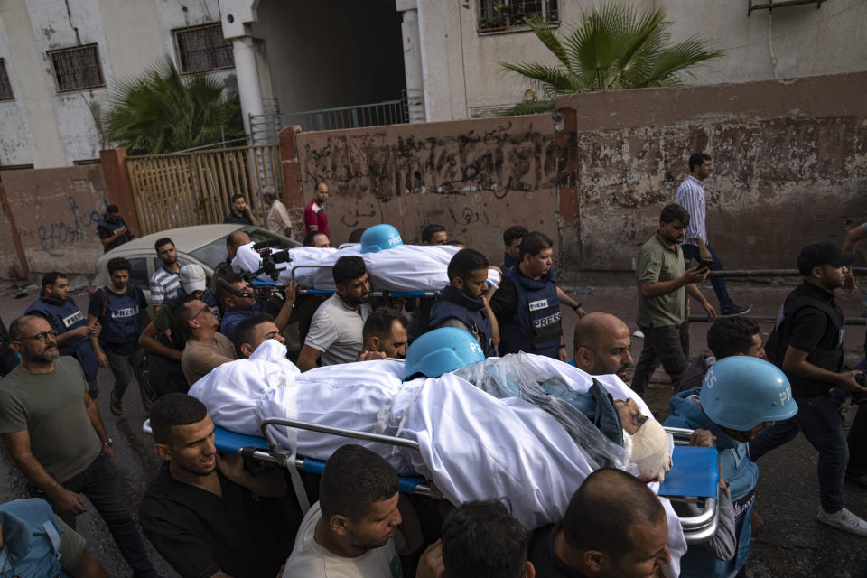 Palestinians, including some journalists, carry the bodies of two Palestinian reporters, Mohammed Soboh and Said al-Tawil, who were killed by an Israeli airstrike in Gaza City, Tuesday, Oct. 10, 2023. The militant Hamas rulers of the Gaza Strip carried out an unprecedented attack on Israel Saturday, killing over 1,000 people and taking captives. Israel launched heavy retaliatory airstrikes on the enclave, killing hundreds of Palestinians. (AP Photo/Fatima Shbair)