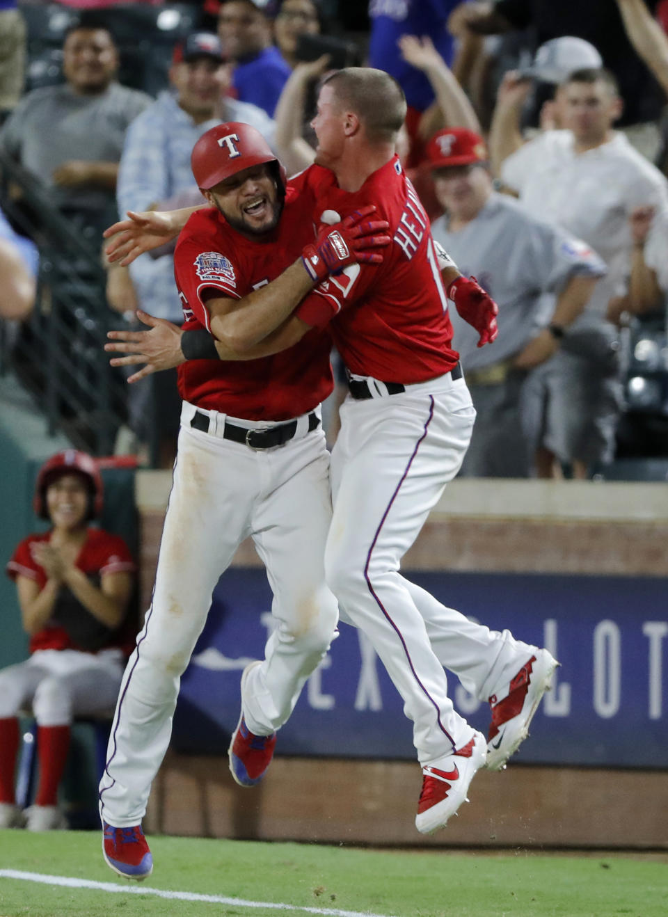 Texas Rangers' Isiah Kiner-Falefa (9) and Scott Heinemann celebrate after Kiner-Falefa hit a run-scoring single in the 11th inning of a baseball game against the Los Angeles Angels in Arlington, Texas, Monday, Aug. 19, 2019. The Rangers won 8-7. (AP Photo/Tony Gutierrez)