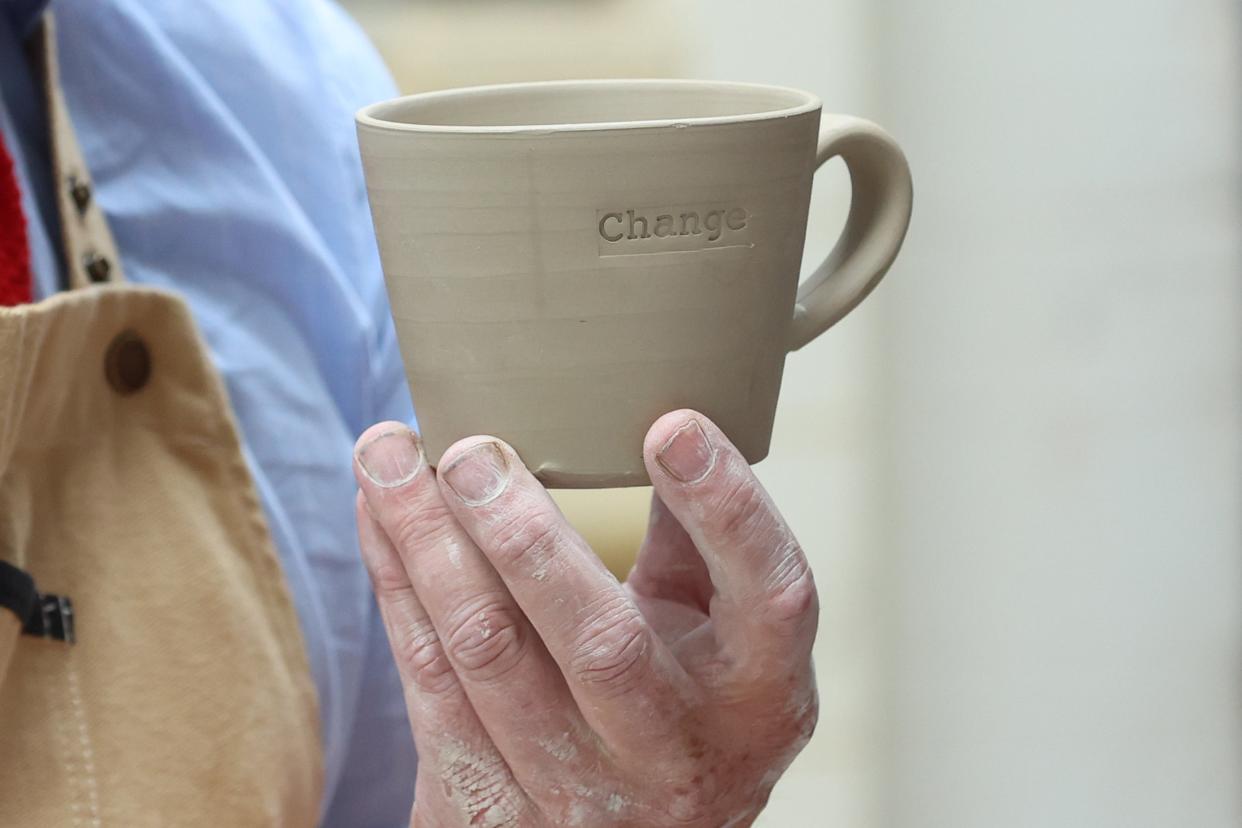 Potter Keith Brymer Jones holds a cup with the word 'Change' printed into it (Getty Images)