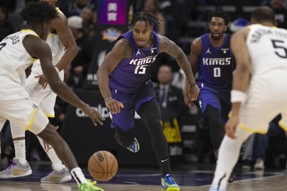 Sacramento Kings guard Davion Mitchell (15) and Utah Jazz forward Taylor Hendricks, left, chase the ball during the first quarter of an NBA basketball game in Sacramento, Calif., Saturday, Dec. 16, 2023. (AP Photo/José Luis Villegas)