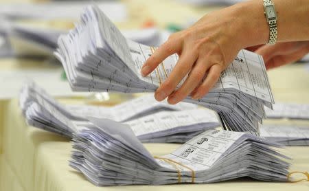 Officials count ballot papers at Witney Leisure Centre in Witney, Britain May 7, 2010. REUTERS/Toby Melville/File Photo