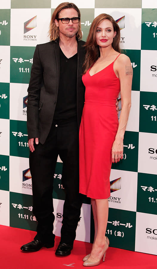 Angelina showed off her tattoos in a form-fitting L'Wren Scott red dress for the Japan premiere of Moneyball in Tokyo in 2011.