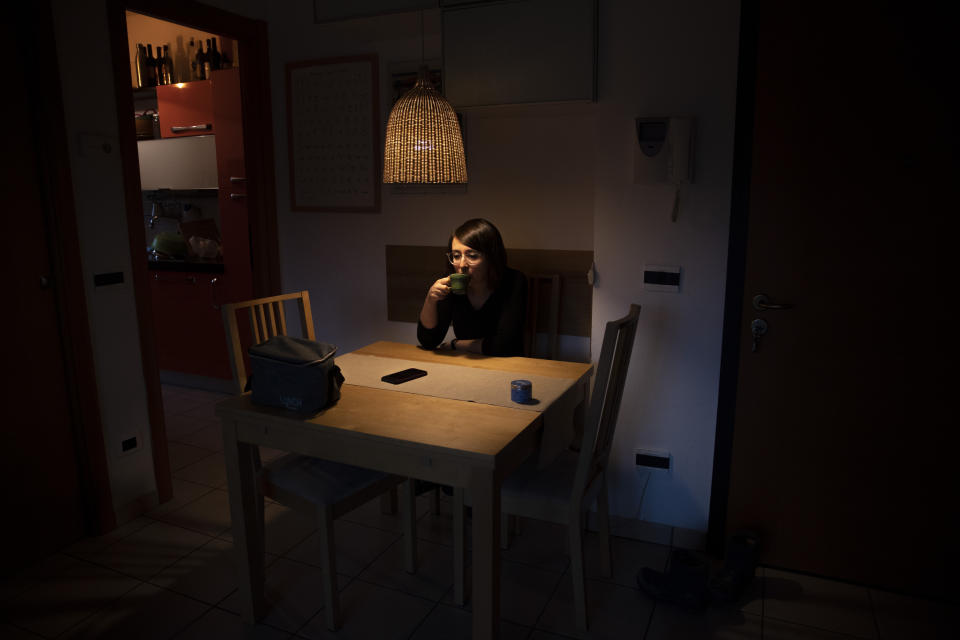 Dr. Elisabetta Teti, a 39-year old infectious diseases specialist, drinks her coffee as she has breakfast in her living room, in Rome, early Saturday, Nov. 7, 2020. The workday begins in darkness, her husband still asleep when she slips out of their apartment for the Tor Vergata Polyclinic Hospital, in the outskirts of Rome. (AP Photo/Alessandra Tarantino)