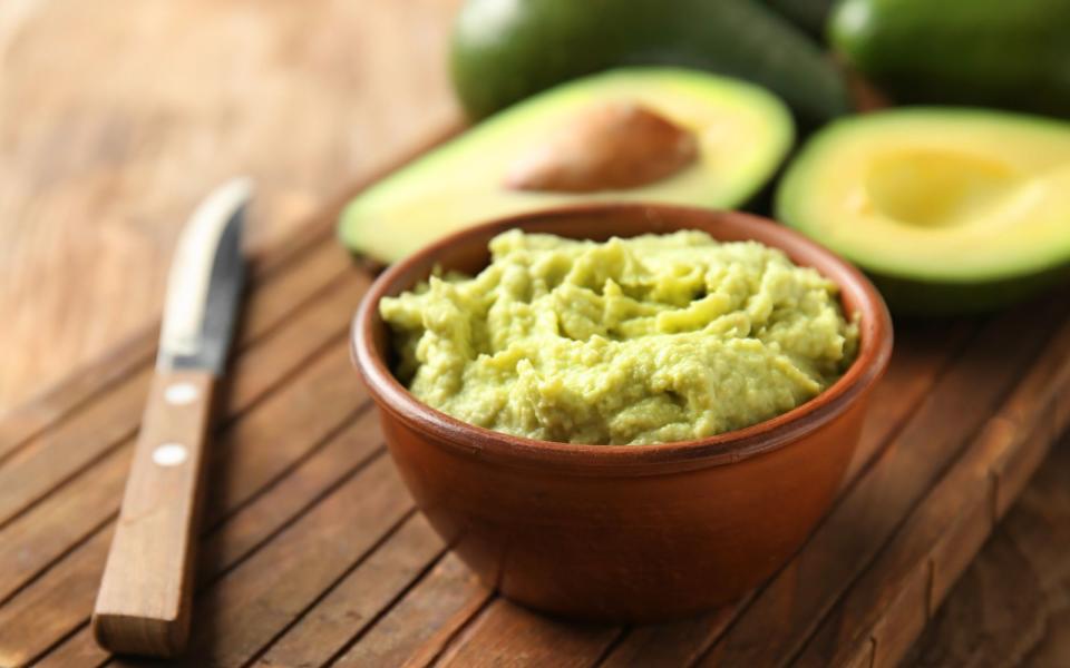 Für selbstgemachte Guacamole löffeln Sie eine reife Avocado aus. Geben Sie eine gehackte Knoblauchzehe, eine gewürfelte Tomate und den Saft einer halben Zitrone zu den Avocadostücken und zerdrücken alles mit einer Gabel, bis es matschig wird. Fehlen nur noch Salz, Pfeffer und Paprikapulver - und schon ist der Dip fertig! (Bild: iStock / serezniy)