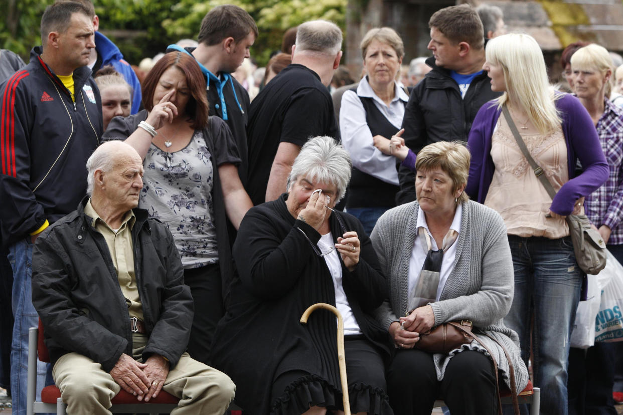 People, including (front row seated from left) Ted and Betty Scones the step father and mother of Darren Rewcastle with Sue and Tracey (purple cardigan), wife and daughter of David Bird, in the grounds of St Nicholas's church in Whitehaven, Cumbria, during the two minute's silence to mark the first anniversary of the shootings in which taxi driver Derrick Bird killed 12 people before he turned his gun on himself.   (Photo by Peter Byrne/PA Images via Getty Images)