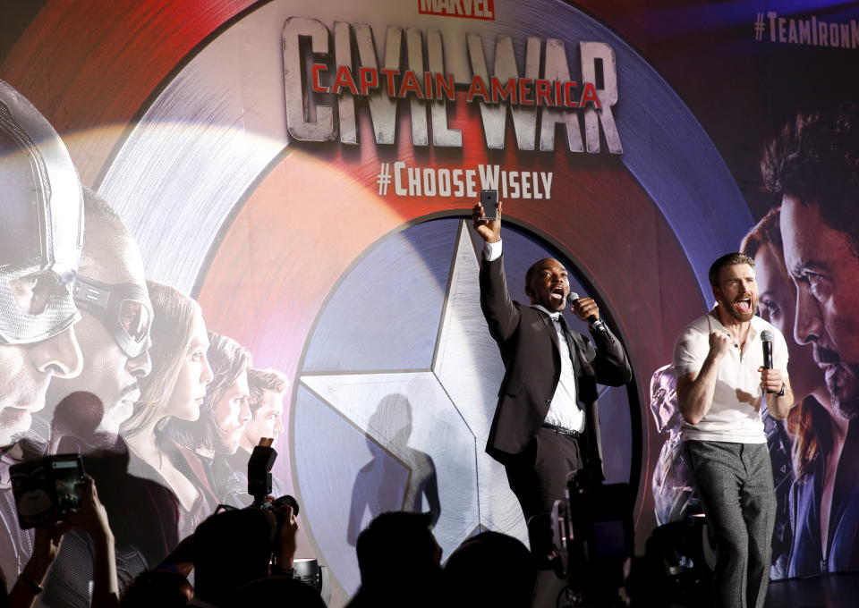 Actors Chris Evans and Anthony Mackie (L) greet fans during a blue carpet event for the movie "Captain America: Civil War" in Singapore, April 21, 2016. REUTERS/Edgar Su 