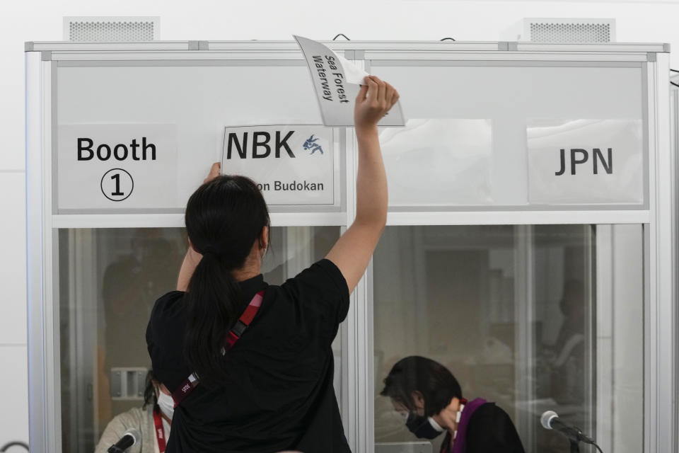 Interpreters work at the main press center during the 2020 Summer Olympics, Friday, July 30, 2021, in Tokyo, Japan. Unlike previous Olympics, all the interpretation is being done remotely with most interpreters working in booths at the main center. Their simultaneous translation can be accessed at all Olympic venues on an app. This eliminates interpreters getting tied up in traffic heading to an venue. (AP Photo/Luca Bruno)