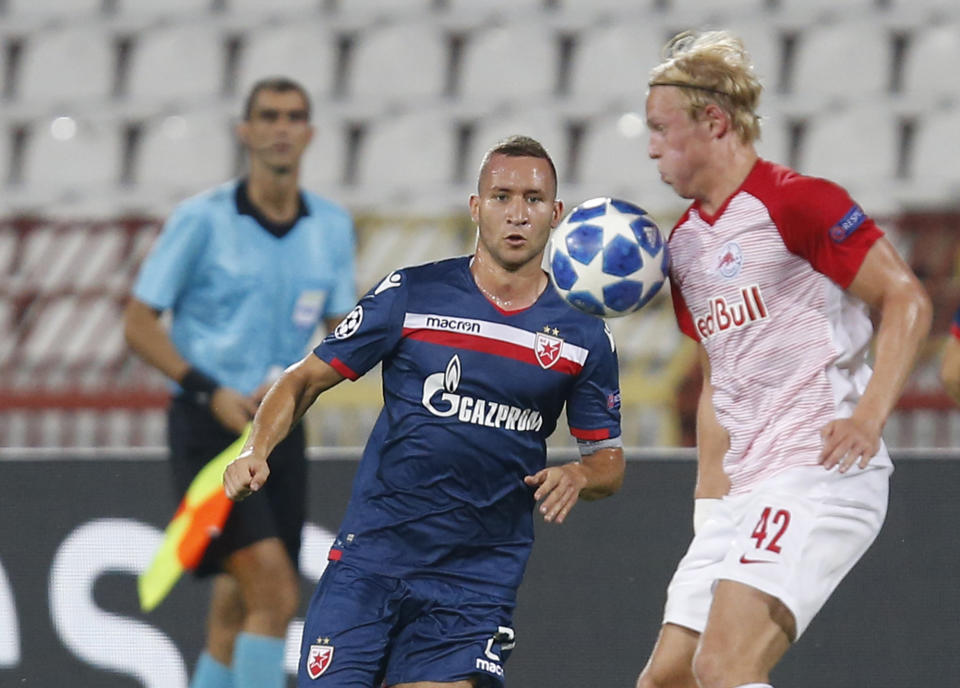 Red Star's Veljko Simic, left, duels for the ball with Salzburg's Xaver Schlager during the Champions League qualifying play-off first leg soccer match between Red Star and Salzburg on the stadium Rajko Mitic in Belgrade, Serbia, Tuesday, Aug. 21, 2018. (AP Photo/Darko Vojinovic)