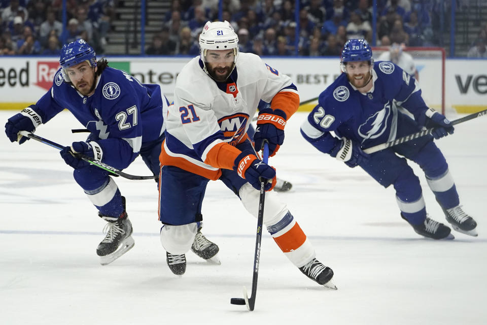 New York Islanders right wing Kyle Palmieri (21) carries the puck past Tampa Bay Lightning defenseman Ryan McDonagh (27) and center Blake Coleman (20) during the first period in Game 1 of an NHL hockey Stanley Cup semifinal playoff series Sunday, June 13, 2021, in Tampa, Fla. (AP Photo/Chris O'Meara)