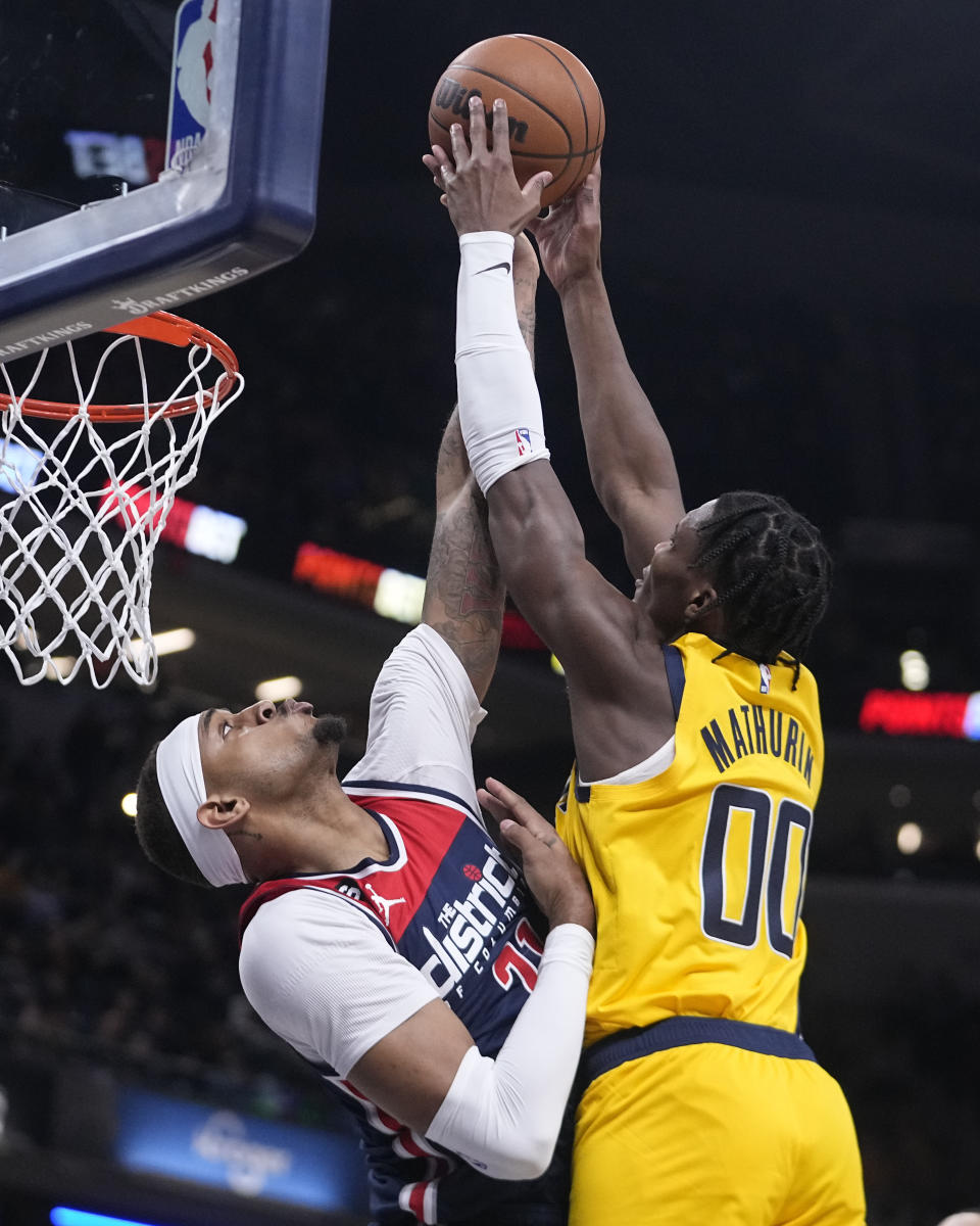 Indiana Pacers guard Bennedict Mathurin (00) has his shot blocked by Washington Wizards center Daniel Gafford, left, during the first half of an NBA basketball game, Friday, Dec. 9, 2022, in Indianapolis. (AP Photo/Darron Cummings)