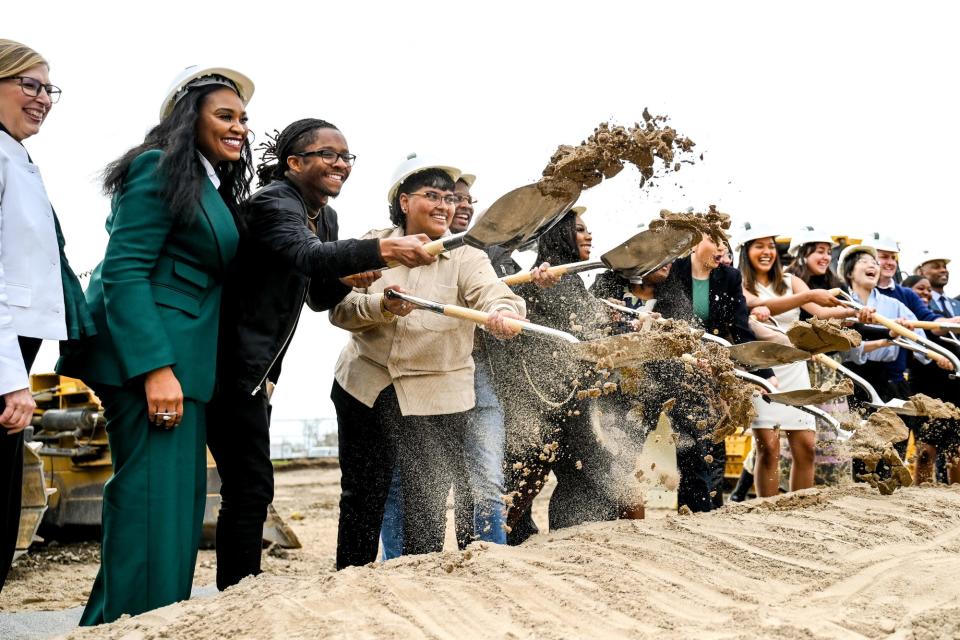 From left, Michigan State University Interim President Teresa Woodruff, MSU Board of Trustees Chairperson Rema Vassar and other leaders and students throw dirt during a groundbreaking ceremony for the MSU Multicultural Unity Center on Friday, April 21, 2023, on campus in East Lansing.