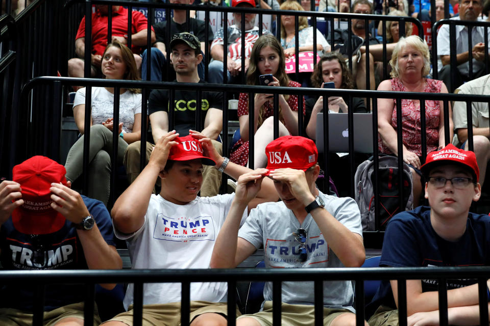 Young Trump supporters straighten their hats