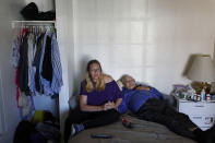 In this Oct. 12, 2018, photo, Celeste Mills, left, holds hands with Gordon Lamb at their room in a weekly rental motel in Reno, Nev. (AP Photo/John Locher)