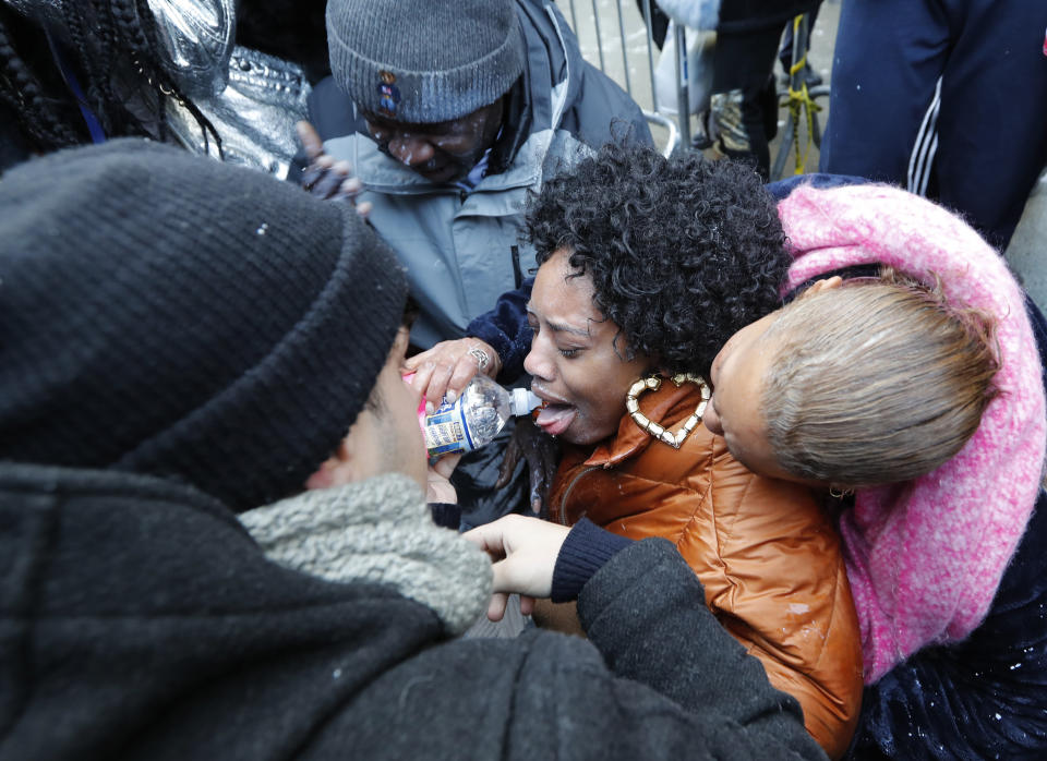 Protesters help Yandy Smith who was sprayed with pepper spray after she and others, including inmates family members, stormed the main entrance to the Metropolitan Detention Center, Sunday, Feb. 3, 2019, in New York. Prisoners have been without heat, hot water, electricity and sanitation due to an electrical failure since earlier in the week, including during the recent frigid cold snap. (AP Photo/Kathy Willens)