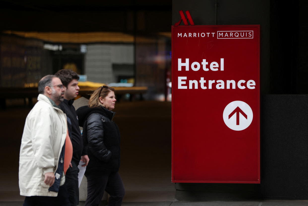 People walk by the Marriott Marquis hotel in Manhattan, New York City, U.S., March 23, 2022. REUTERS/Andrew Kelly