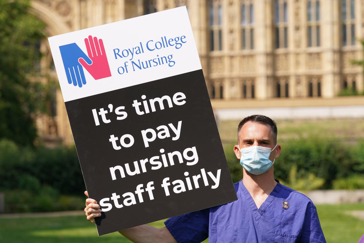 A nurse with a Royal College of Nursing placard. (PA)