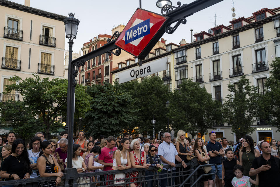 Aficionados a la ópera y transeúntes observan una representación de "Turandot", de Giacomo Puccini, en una pantalla gigante instalada el exterior del Teatro Real de Madrid, el 14 de julio de 2023. Desde hace ocho años, el Teatro Real ofrece la retransmisión gratuita de las óperas que se representan en su escenario a pueblos y ciudades de toda España. El objetivo es incentivar el interés por la ópera y librarla de su etiqueta de elitista. (AP Foto/Bernat Armangué)