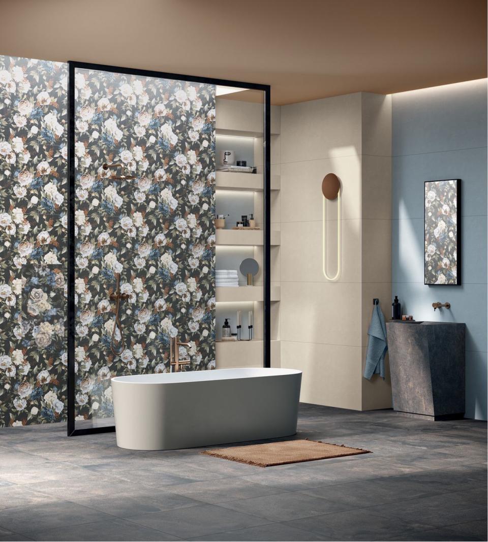 lit bathroom shelves next to floral wallpaper and a modern bath tub