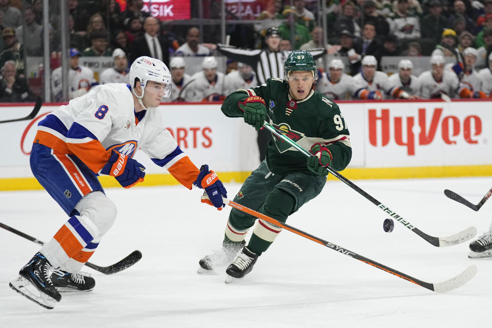 New York Islanders defenseman Noah Dobson (8), left, and Minnesota Wild left wing Kirill Kaprizov follow the puck during the first period of an NHL hockey game Tuesday, Feb. 28, 2023, in St. Paul, Minn. (AP Photo/Abbie Parr)