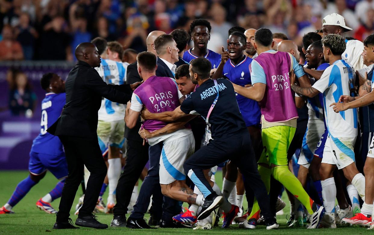 Castello Lukeba of France clashes with Argentina players after the match