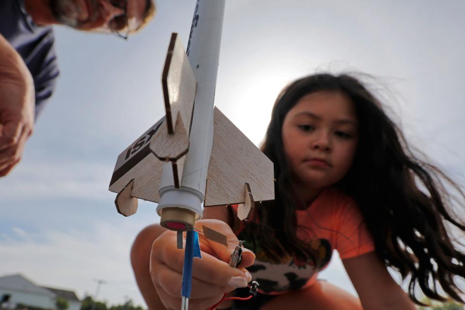 Cali Zwacki, 9, attaches the firing contacts to the rocket that she and her father David Zwacki built, before firing the rocket into the sky at the DYAA field in Dartmouth.