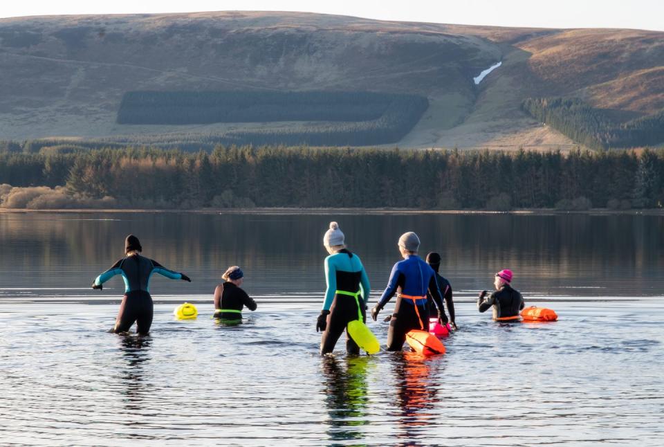 wild swimmers wading in to a freshwater reservoir