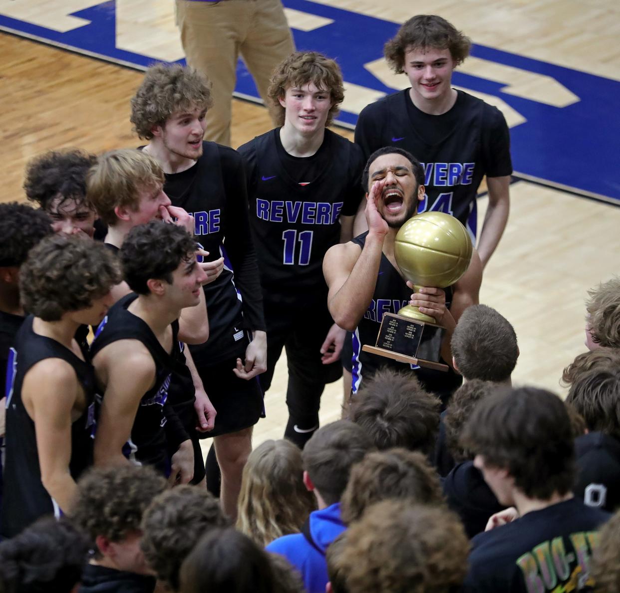 Revere's Carson Banks, center, celebrates winning the Gold Ball Trophy with his teammates, including Greg Cochran (32), Conner Groce (11) and Luke Butler (24), after beating host Copley, 67-58, in a high school basketball game, Friday, Jan. 26, 2024.