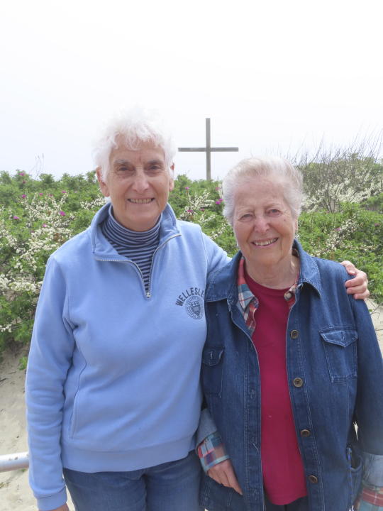 Luisa Paster, left, and Harriet Bernstein, right pose on the boardwalk in Ocean Grove, N.J. on May 2, 2024, near a pavilion where a religious group that owns all the land in Ocean Grove refused to let them hold a civil union ceremony in 2007.The state of New Jersey says the Ocean Grove Camp Meeting Association is violating state beach access laws by keeping people off the beach until noon on Sundays. (AP Photo/Wayne Parry)
