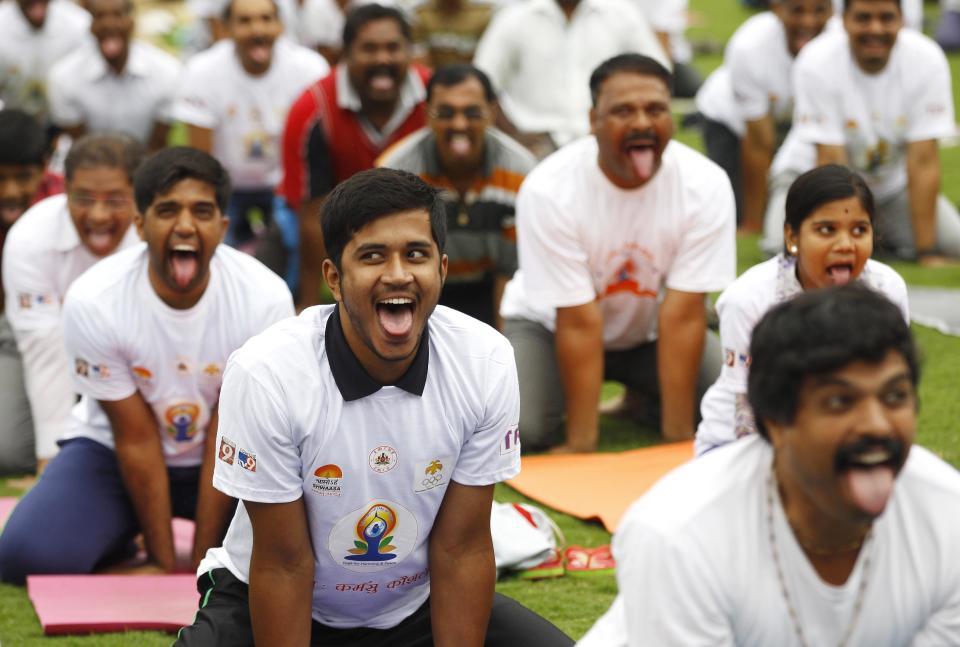 Indians perform yoga at an event to celebrate the International Yoga Day in Bangalore, India, Sunday, June 21, 2015. Millions of yoga enthusiasts are bending their bodies in complex postures across India as they take part in a mass yoga program to mark the first International Yoga Day. (AP Photo/Aijaz Rahi)