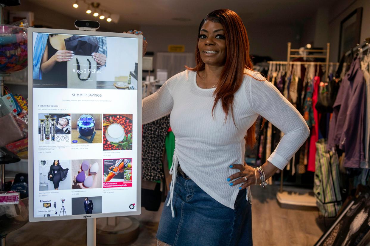 Lillie Williams, owner of Rags 2 Riches, a wholesale and consignment store, stands by the electronic display inside of her store on April 29, 2024, in Pickerington, Ohio.