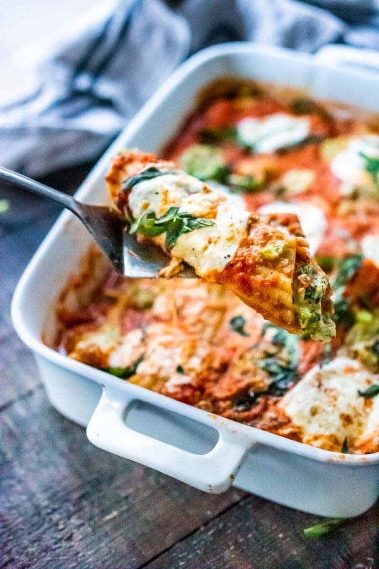 one piece of broccoli manicotti being served out of a baking dish