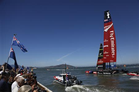 Emirates Team New Zealand sails past the spectators on shore after defeating Oracle Team USA in Race 11 of the 34th America's Cup yacht sailing race in San Francisco, California September 18, 2013. REUTERS/Stephen Lam