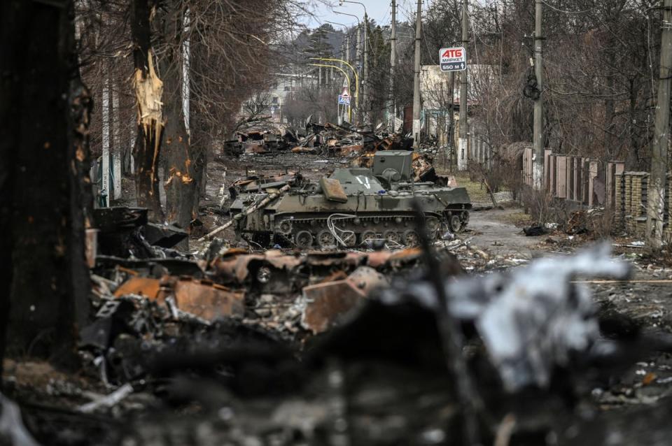 A woman navigates a debris-filled Bucha street in April (AFP/Getty)