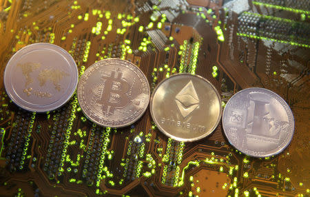 FILE PHOTO: Representations of the Ripple, Bitcoin, Etherum and Litecoin virtual currencies are seen on a PC motherboard in this illustration picture, February 13, 2018. REUTERS/Dado Ruvic/File Photo