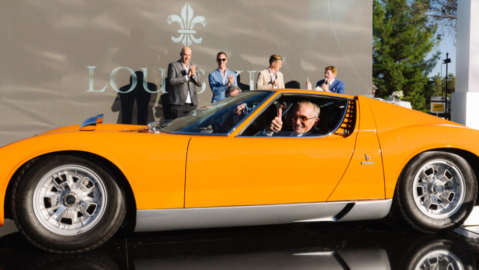 Jeffrey Meier of Woodlands Hills, Calif., drives his 1969 Lamborghini Miura S across the concours stage to accept the Best of Show award among the Postwar entries.