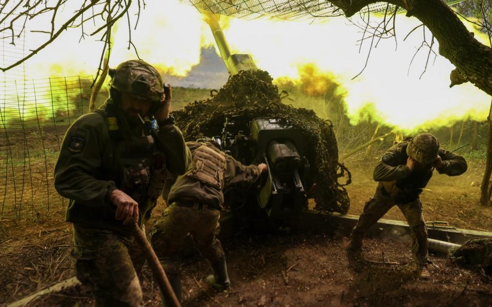 Ukrainian servicemen of fire a D-30 howitzer near Soledar - Reuters