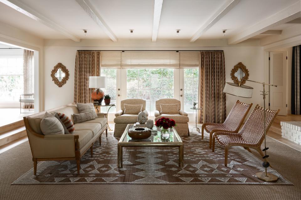 The interior was kept rather simple in the main living room, which has openings onto other rooms of the house on its three sides. A mix of old (such as the pair of antique gilt frames) and new (a graphically printed rug by Amadi Carpets in Los Angeles) add depth and sophistication.