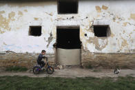 Milan Bastyur, a 4 year old Hungarian Roma child, rides a bike outside his family's home in Bodvaszilas, Hungary, Monday, April 12,2021. Many students from Hungary's Roma minority do not have access to computers or the internet and are struggling to keep up with online education during the pandemic. Surveys show that less than half of Roma families in Hungary have cable and mobile internet and 13% have no internet at all. (AP Photo/Laszlo Balogh)