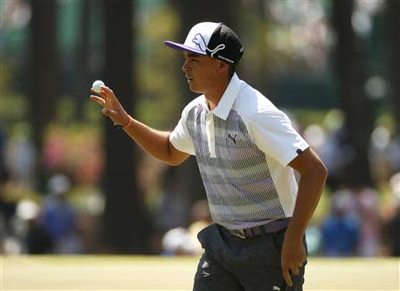 U.S. golfer Rickie Fowler waves to the gallery after a birdie on the third hole during the third round of the Masters golf tournament at the Augusta National Golf Club in Augusta, Georgia April 12, 2014. REUTERS/Jim Young